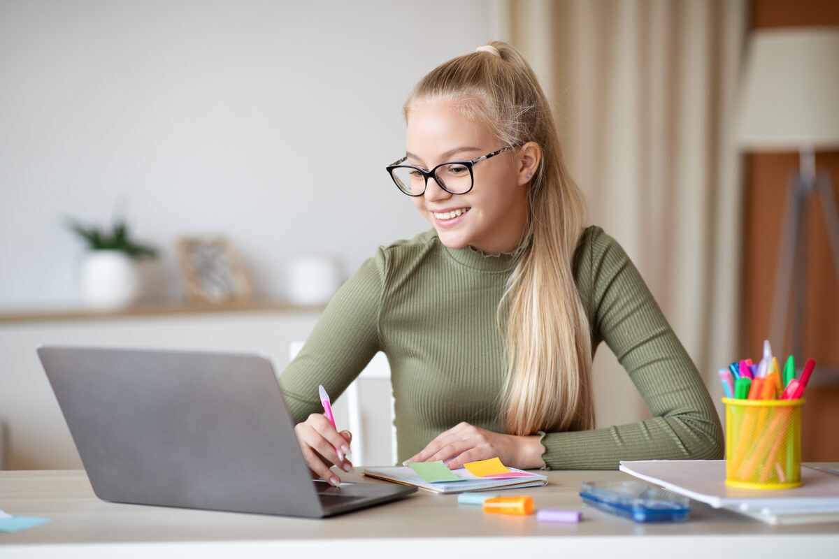 cute-teen-girl-taking-notes-and-using-laptop-XU2JZR4.jpg